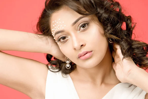 Katı pembe bir arka plan önünde nakışlı bir elbise giyen güzel Hintli kadın manken.