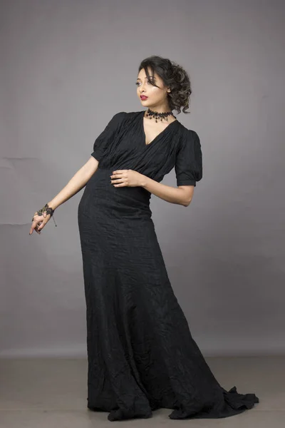 Mooi Vrouwelijk Model Modieuze Zwarte Jurk Voor Een Solide Achtergrond — Stockfoto
