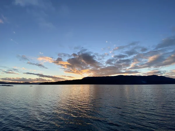 Hermoso atardecer sobre montañas con reflexión sobre el agua — Foto de Stock