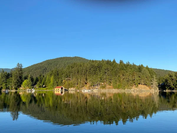 Perfect reflection of a small hill in Bargain Bay, near Pender Harbour — Stock Photo, Image