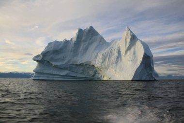 Kuzey Kutup Bölgesi 'nde, Nunavut, Kanada' da, Pond Inlet yakınlarında, akşam saatlerinde karaya oturmuş buzdağı ve buz