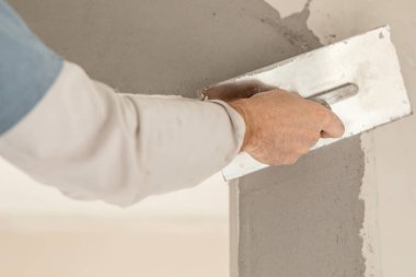 ustanın eli duvarları kaplıyor, daireyi onarıyor, yakın plan, evi yenileme ve yenileme konsepti