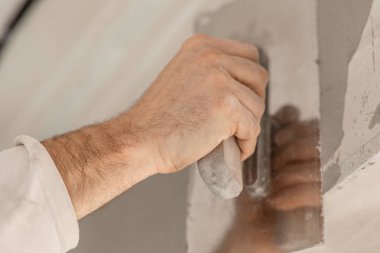 ustanın eli duvarları kaplıyor, daireyi onarıyor, yakın plan, evi yenileme ve yenileme konsepti