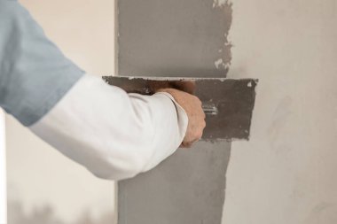 ustanın eli duvarları kaplıyor, daireyi onarıyor, yakın plan, evi yenileme ve yenileme konsepti