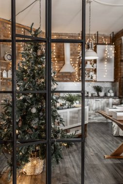 rustic kitchen interior on a brick wall background with lamps and a fir tree decorated for Christmas 