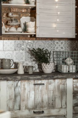 details of a cozy view of the kitchen interior in a rustic style with lamps and a fir tree decorated for Christmas