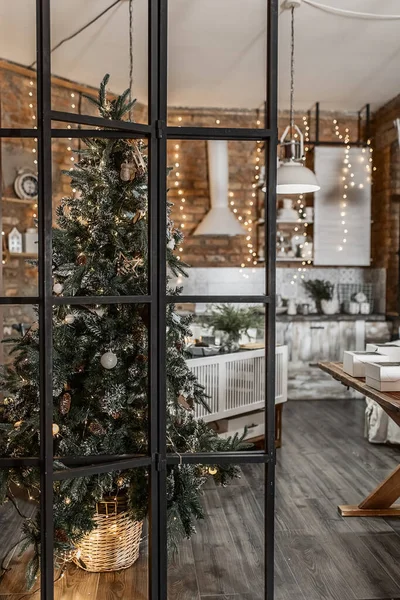 rustic kitchen interior on a brick wall background with lamps and a fir tree decorated for Christmas 