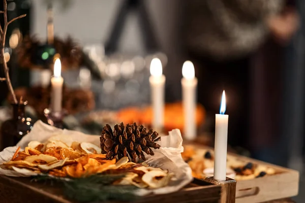 festive table with burning candles and a cone of Christmas and New Year's bokeh concept, interior details, selective focus