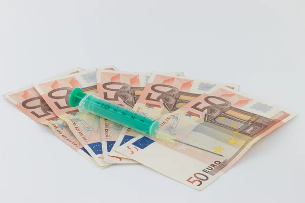 注射器与欧元纸币上的绿色瓶 — 图库照片