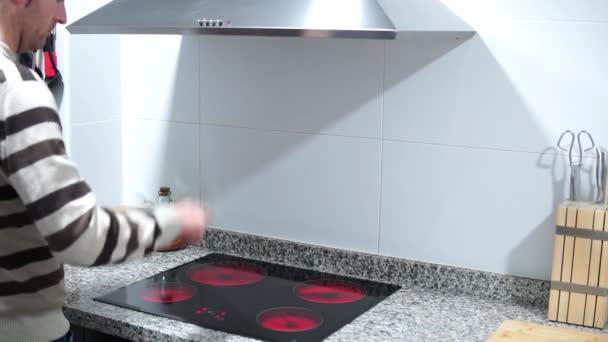 Middle aged man switches off extractor light and ceramic stove to save electricity. Concept energy price rise. — Wideo stockowe