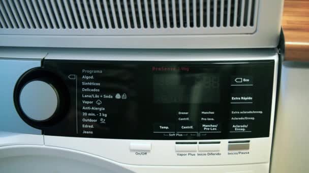 세탁기 패널의 면밀 한 초점, 스페인어 및 도자기 기계 에서 ECO 프로그램을 설정 사람의 손. 에너지 비용 인상의 개념. — 비디오