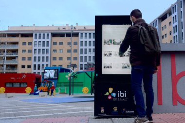 Adam şehir merkezinde turistik bilgi için teknoloji ekranı kullanıyor.