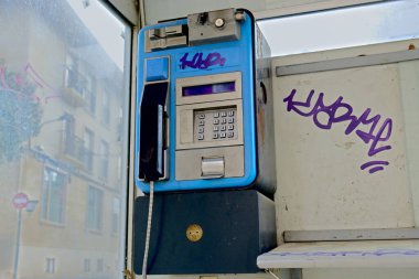 Şubat 2022. Ibi, Alicante, İspanya. Sokağın karşısındaki köhne ve kirli telefon kulübesi. Tüm telefon kulübeleri tüm ülkeden kaldırıldı, eski teknoloji, karsız iş. Yüksek kalite fotoğraf