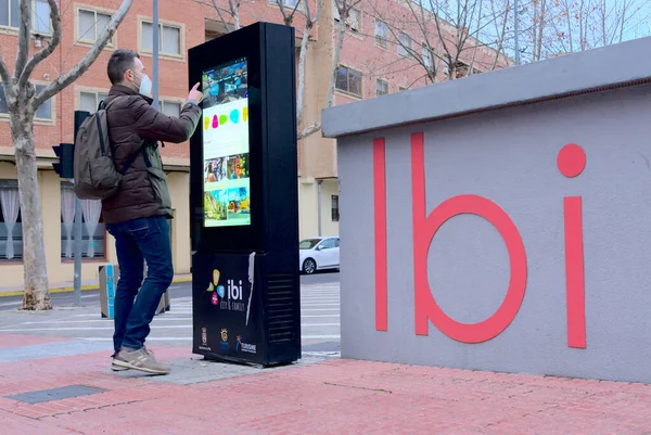 Homem usando tecnologia touch screen para informações turísticas no centro da cidade — Fotografia de Stock