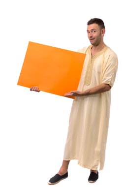 Beyaz arka planda Arap djellabası takan yakışıklı beyaz bir adamın kopyası. Kameraya bakıp gülümsüyor. Boş turuncu pankartı tutuyor. Yüksek kalite fotoğraf
