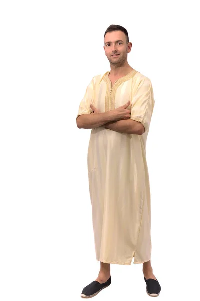 Beyaz arka plan üzerine Arap djellabası giymiş, kolları bağlı, orta yaşlı, yakışıklı beyaz bir adam resmi. Kameraya bakıp gülümsüyor. İş hayatında güven kavramı. Yüksek kalite