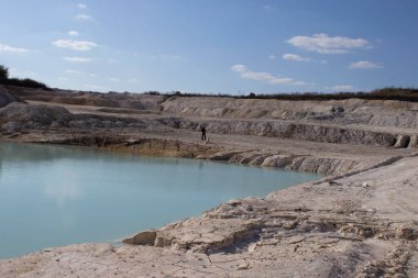 Yazın açık çukur, şehrin dışında mavi suyla.