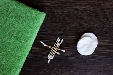 Ahşap bir arka planda kulaklar için pamuk bezleri ve yüz ve vücut bakımı için pamuk pedleri her gün için.