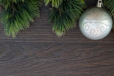 Noel süslemeleri, mutlu yıllar 2022, Noel ağacı dallı parlayan ahşap arka plan, çam kozalağı ve yeni yıl balosu.