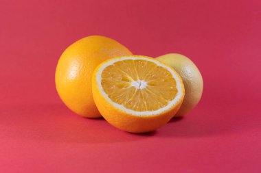 Kırpma yolu ile kırmızı zemin üzerinde sulu portakal ve limon izole