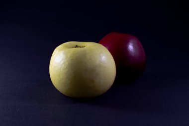 Koyu arkaplanda sarı ve kırmızı elma.