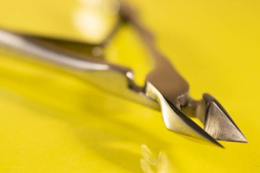 Sarı arka planda manikür için makas ve aletler, üst manzara. Tırnak aleti, makro fotoğrafçılık. Evde manikür.. 