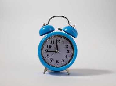 Çalar saat mavinin üstünde. Zaman kavramı. Sabah vakti mavi alarmlı saat. Mavi alarm saati mavi kopya alanı.