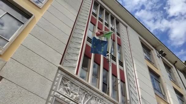 ヨーロッパとイタリアの旗が一緒にイタリアの建物でEu 雲と青空イタリアとユニオンヨーロッパのフラグの織物テクスチャを振る — ストック動画
