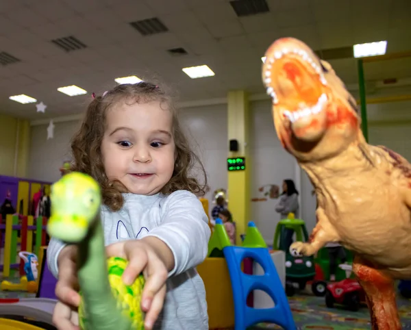 Şirin, güzel küçük kız dinozorlarla oynuyor. Yakından Kız Oyuncaklarla Korkutur. Oyun sahasında sağlıklı, mutlu çocuk..
