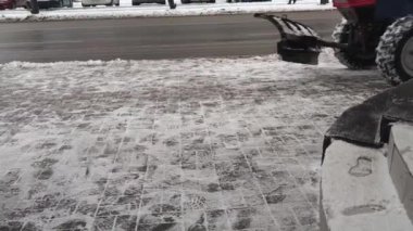 Zhytomyr, Ukrayna - 30 Ocak 2022: Şiddetli yağış sonrasında kaldırımdan traktör temizliği. Kazıcıların Toplu Kar 'dan Temizlendiği Şehir Sokakları. Mevsimlik kavramı.