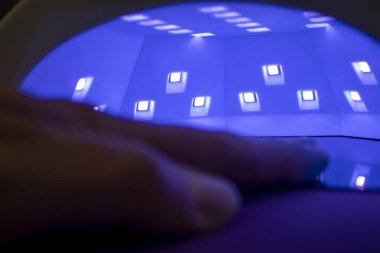 UV lambası. Ultraviyole lambadaki çivileri kurutmak. Tırnak cilası üstüne oje. Tırnak bakımı.