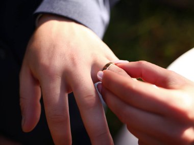 Evlilik yüzükleri. Düğündeki Gelin Yüzüğü Damadın Eline Koyuyor. Gelin ve damadın alyansı takışının yakın plan görüntüsü, bulanık arkaplan. Düğün ve Tatil Konsepti.