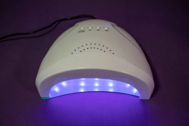UV Nail Lambası. Çeşitli Amaçlar İçin UV Işıklı Özel UV Lambaları. Manikürlü Nails in UV lamp in Beauty Salon. Işık terapisi, fototerapi..