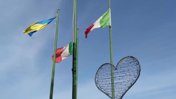 旗竿にヨーロッパの旗が風になびいていた 晴れた日に手を振っているウクライナとイタリアの国旗 — ストック動画