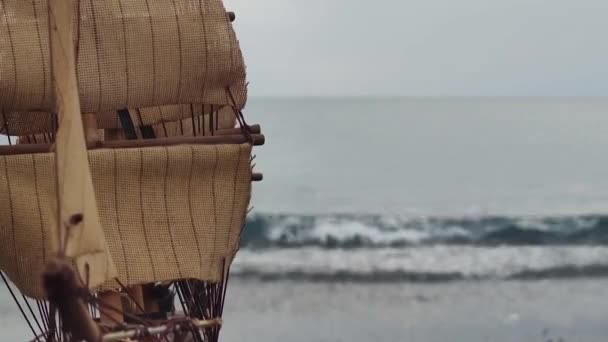 海の波を背景にした帆船カタマランの模型 暖かい日にボート 素晴らしいティレニア海の背景にイタリアの南風からヨットの帆を閉じる — ストック動画