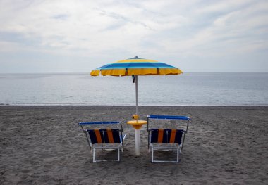 Şemsiyeler ve Sunbed sahilde. Eğlence ve turizm konsepti. İtalya sahilinde güneşli yataklar. Yaz ve Seyahat konsepti. Güneş pansiyonları ve Şemsiyeli plaj.