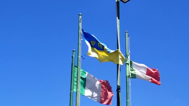 ウクライナとイタリアは 青い空に対して旗竿にフラグを立てます イタリア共和国とウクライナの国旗 友情と支援の象徴 スローモーション — ストック動画