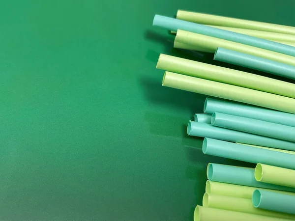 Straws. Close-up of blue and green plastic straw collection on colored background. Colorful straw.