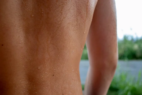 Sweat on the Skin, very close-up. Drops of Sweat on Tanned Skin. Drops of Water on the Skin of a Guy, Close-up of the Wet Texture of a Man's Skin. Full Frame Shot of Sweat on Skin.