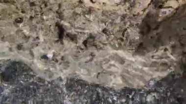Beyaz Kum Kumsalı 'na Yuvarlanan Dalgaların Yakın Çekimi. Su yüzeyi dokusu döngüsü, güneş doğal berrak mavi su..