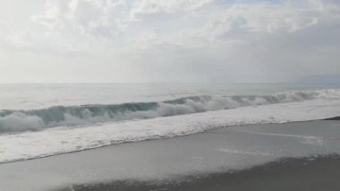 Denizin masmavi sularının görüntüsü, deniz dalgaları üzerinde güneş gören animasyon ve ufuktaki bulutlar 4K. Cennet sahili hava görüntüsü.