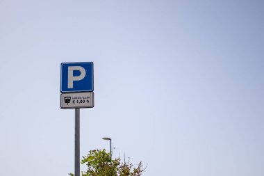Park tabelası. Mavi gökyüzüne karşı bir yol işaretinin alçak açılı görüntüsü. Yol işareti: park.