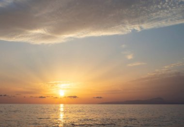 Okyanusun üzerinde renkli bir gün doğumu. Denizin üzerinde güzel dramatik altın gökyüzü ve yazın günbatımında yansıma, uzun süre maruz kalma..