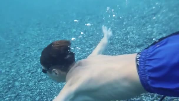 Boy Swims Underwater Blue Sea Guy Wearing Diving Goggles Water — Stockvideo