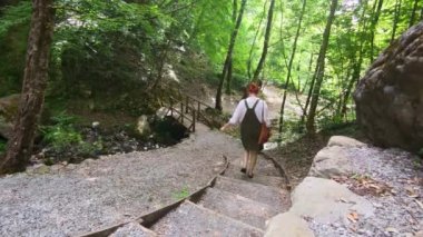 The girl Goes Down the Stone Steps Among Exotic Plants in the Reserve. Picturesque Place of Nature in the Open Air. Travel Europe, Calabria, Italy. Slow motion.