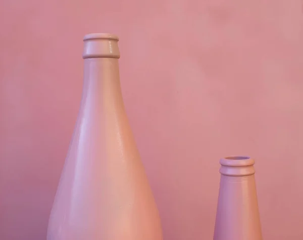 Close-up of Two Empty Bottles. Pink Bottles on a Pink Background. Copy Space for Text.