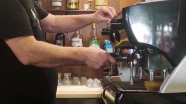 Italy, Scalea, August 15, 2022: Barista Prepares Coffee in a Coffee Machine. Work in a Bar in a Restaurant. A Man Prepares a Delicious Cappuccino in Southern Italy, in Calabria.