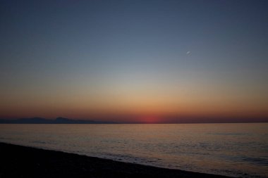 Colorful Panoramic View of the Coast of Calabria With a Cloudy Sunset Sky, Tyrrhenian Sea and Mountains in the Background. Sunset by the Sea.