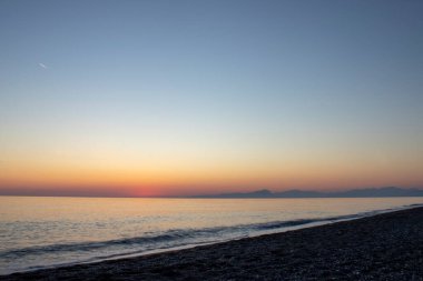 Colorful Panoramic View of the Coast of Calabria With a Cloudy Sunset Sky, Tyrrhenian Sea and Mountains in the Background. Sunset by the Sea.