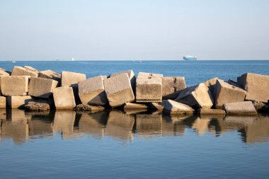 Sea stones. Steps in the Blue Sea. Beautiful Reflection of Stones in the Clear Turquoise Sea at Dawn.